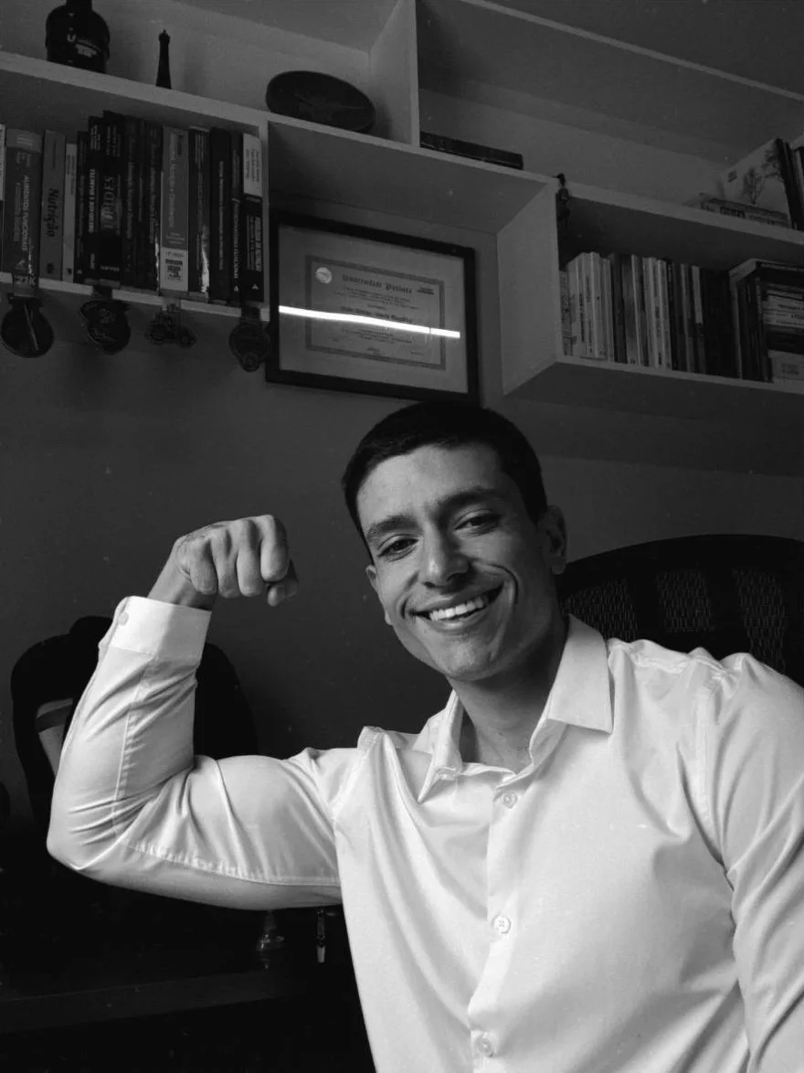 Pedro Almeida sorrindo, de camisa social, em foto em preto e branco